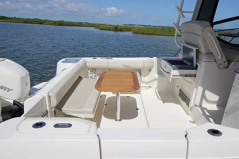  Yacht Photos Pics Manufacturer Provided Image: 2021 Boston Whaler 325 Conquest boat deck with seating and table on calm water.