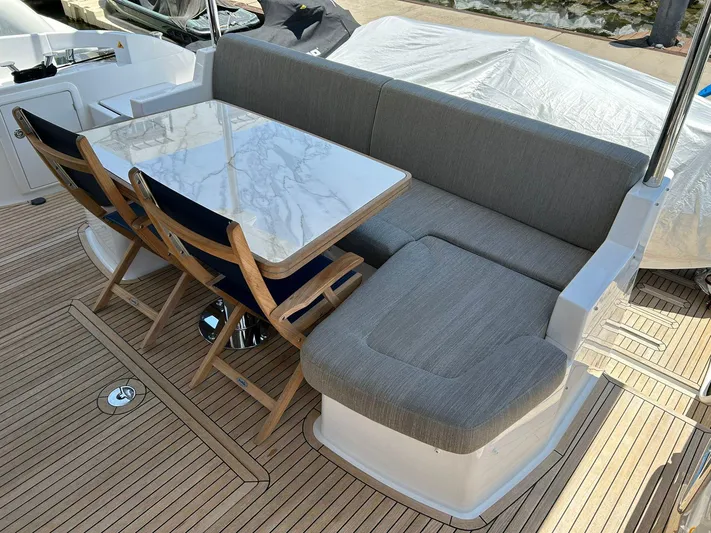 2021 Azimut 55 Fly @vallarta  Yacht Photos Pics Azimut 55 yacht 2021, outdoor seating with table and chairs on teak deck.