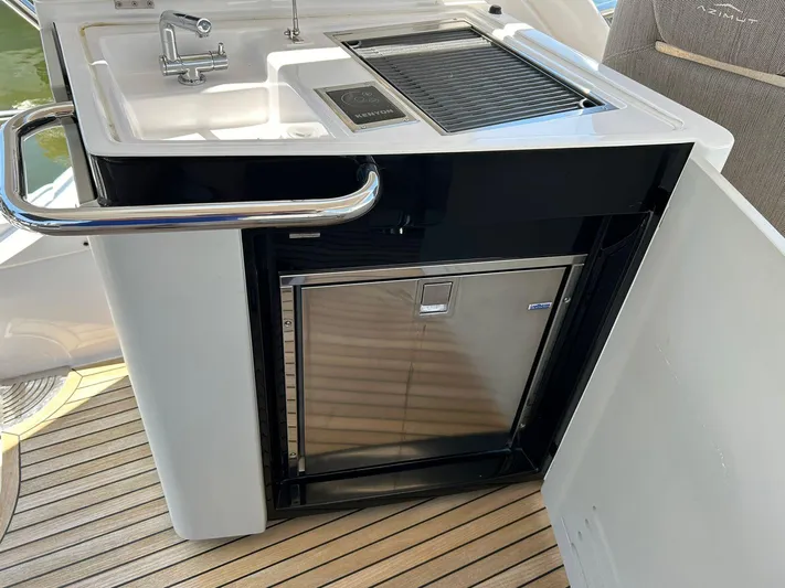 2021 Azimut 55 Fly @vallarta  Yacht Photos Pics Outdoor kitchenette on 2021 Azimut 55 yacht with sink, grill, and fridge.