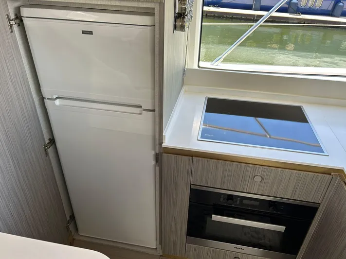 2021 Azimut 55 Fly @vallarta  Yacht Photos Pics Modern kitchen in 2021 Azimut 55 yacht with fridge, stove, and oven.