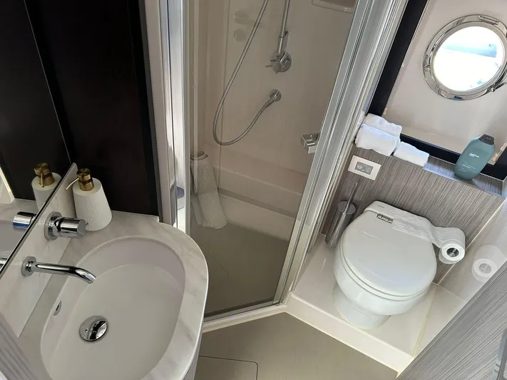 2021 Azimut 55 Fly @vallarta  Yacht Photos Pics Modern bathroom in 2021 Azimut 55 yacht with shower, sink, and toilet.