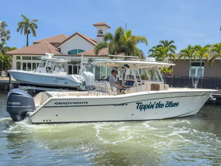  Yacht Photos Pics 2010 Grady-White Canyon 336 boat on water, with palm trees and house in background.