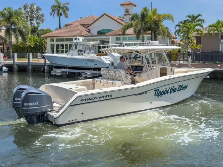  Yacht Photos Pics 2010 Grady-White Canyon 336 boat cruising in a sunny waterfront setting.