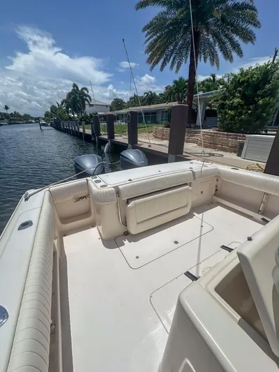  Yacht Photos Pics 2010 Grady-White Canyon 336 boat docked by a scenic waterfront with palm trees.