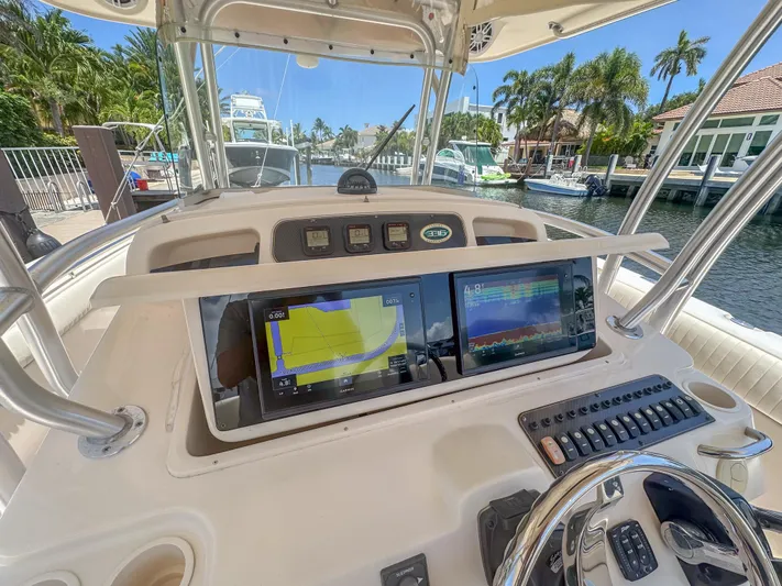  Yacht Photos Pics Grady-White Canyon 336 boat dashboard with navigation screens, docked in a scenic marina.