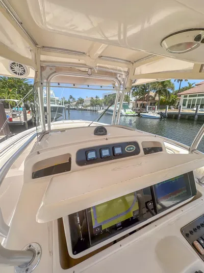  Yacht Photos Pics 2010 Grady-White Canyon 336 boat dashboard with navigation equipment, docked by a scenic waterfront.