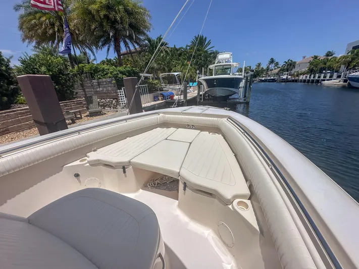  Yacht Photos Pics 2010 Grady-White Canyon 336 boat docked by a scenic canal with palm trees.