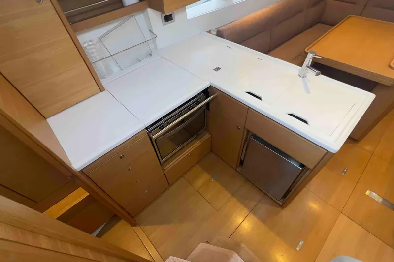  Yacht Photos Pics Modern kitchen interior of 2015 Grand Soleil 39 Maletto yacht, featuring sleek cabinetry and appliances.