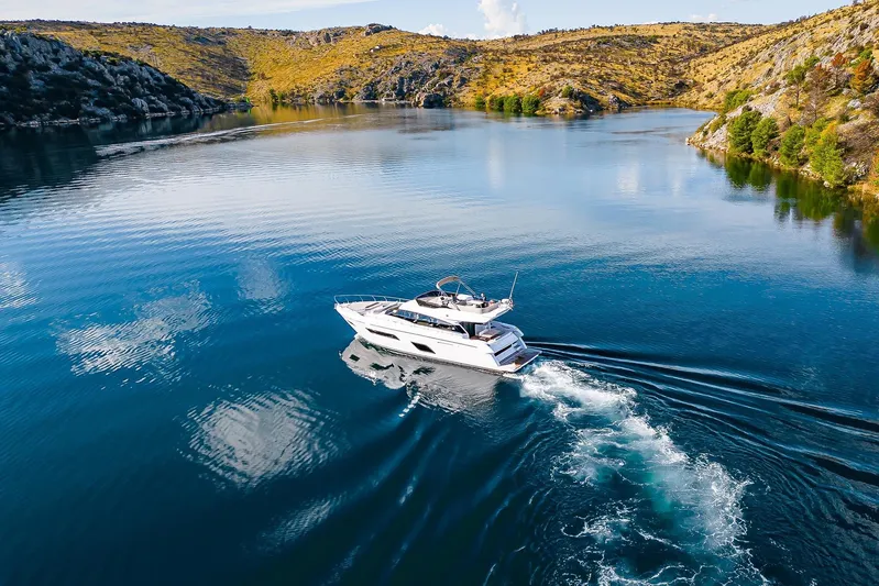 M/y La Seduction Yacht Photos Pics 2022 Ferretti Yachts 550 cruising on a serene lake surrounded by hills.