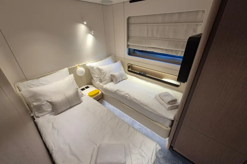  Yacht Photos Pics Luxurious twin cabin in 2025 Azimut Grande 26M yacht, featuring modern design and cozy bedding.