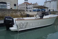 Rhea 27 Open V2 boat docked, featuring Suzuki outboard motor, 2026 model.