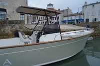 2026 Rhea 27 Open V2 boat docked in a quaint harbor setting.