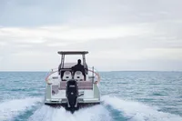2026 Rhea 27 Open V2 boat cruising on open water, rear view.