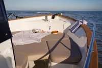 Luxurious Rhea 27 Open V2 boat deck with cushions, 2026 model, on serene ocean waters.