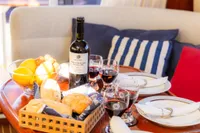 Luxurious dining setup on 2010 Storebro 435 Commander yacht with wine, bread, and fruit.