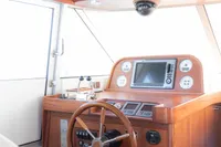 Interior helm of 2010 Storebro 435 Commander yacht with wooden steering wheel and navigation instruments.