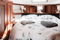 Luxurious cabin interior of 2010 Storebro 435 Commander yacht with nautical-themed bedding.