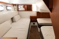 Interior of 2010 Storebro 435 Commander yacht with twin beds and wooden cabinetry.