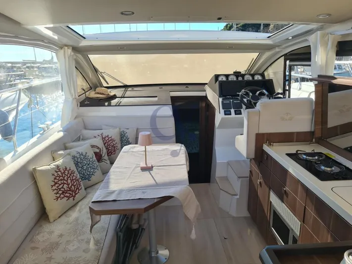 P Yacht Photos Pics Interior of 2018 Sealine C330 yacht with cozy seating, dining table, and helm station.