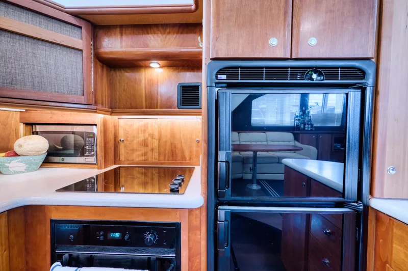 Turn The Paige Yacht Photos Pics Silverton 43 Motor Yacht 2003 kitchen with wooden cabinets and appliances.