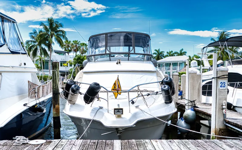 Turn The Paige Yacht Photos Pics 2003 Silverton 43 Motor Yacht docked, surrounded by palm trees.