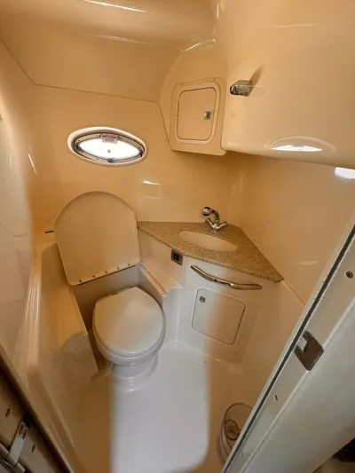 The Boardroom Yacht Photos Pics 2008 Sea Ray Sundancer bathroom with compact design, featuring a toilet, sink, and small window.