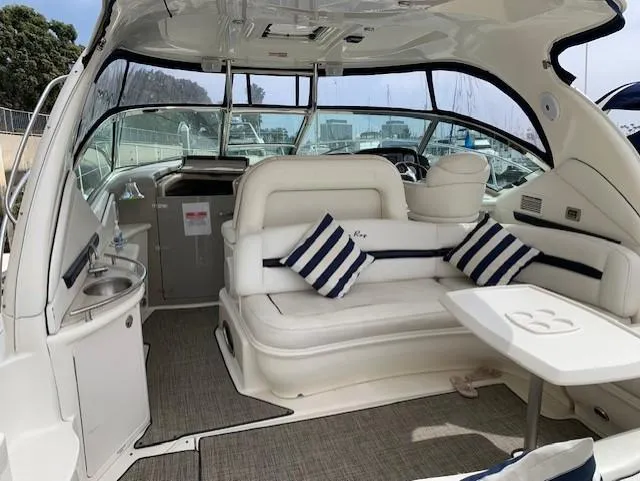 The Boardroom Yacht Photos Pics 2008 Sea Ray Sundancer interior with white seating, striped pillows, and a small table.