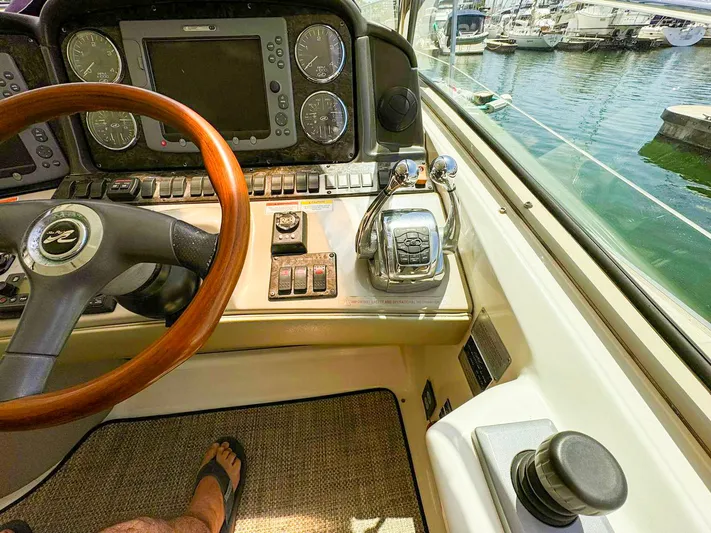 The Boardroom Yacht Photos Pics 2008 Sea Ray Sundancer helm with wooden steering wheel and control panel, docked at marina.