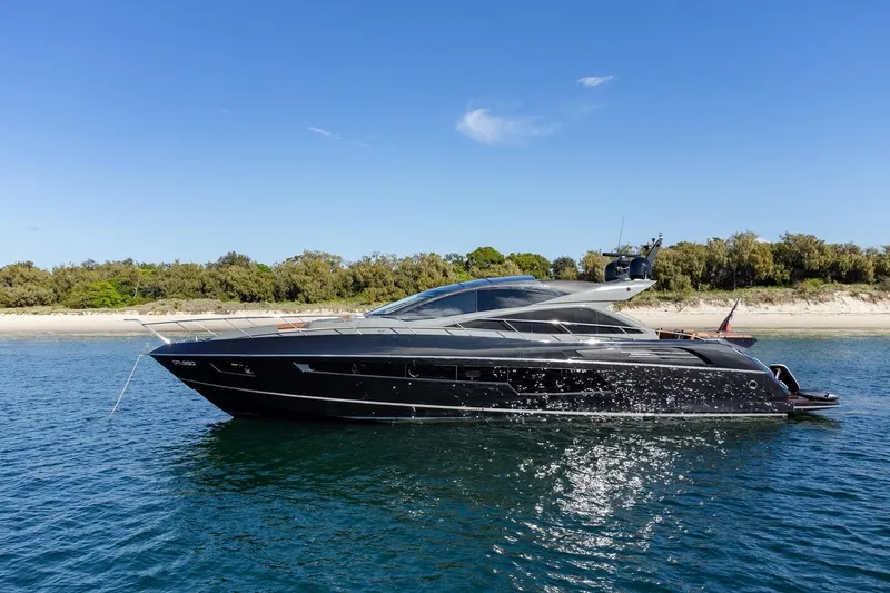 Zaza Yacht Photos Pics 2013 Sunseeker Predator 68 yacht on calm water near a sandy beach.