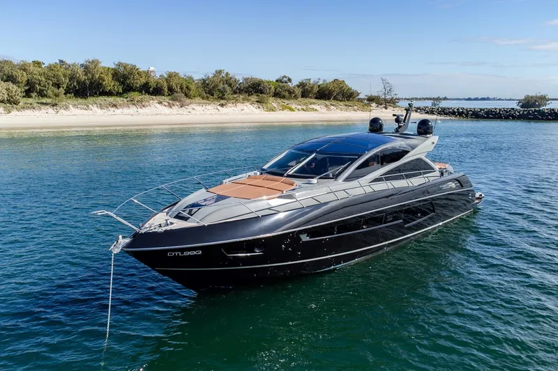 Zaza Yacht Photos Pics Luxurious 2013 Sunseeker Predator 68 yacht anchored near a scenic shoreline.