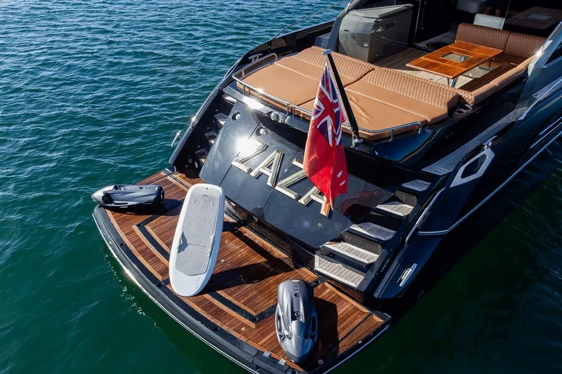 Zaza Yacht Photos Pics Luxurious 2013 Sunseeker Predator 68 yacht with water toys on deck, docked in serene waters.