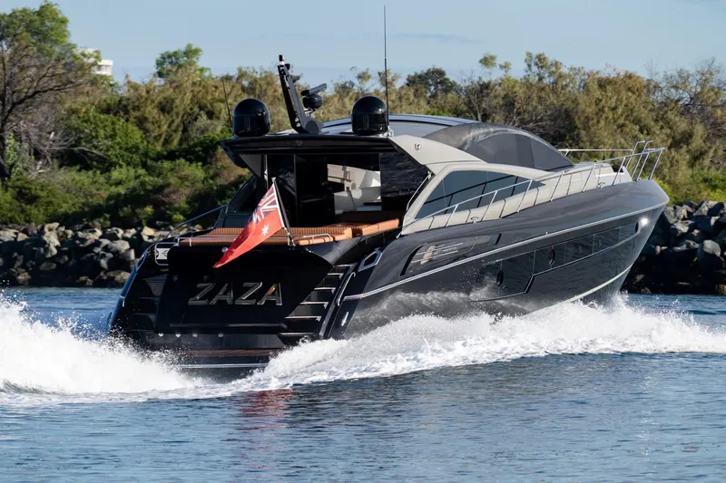 Zaza Yacht Photos Pics 2013 Sunseeker Predator 68 yacht cruising on water, rear view with flag.