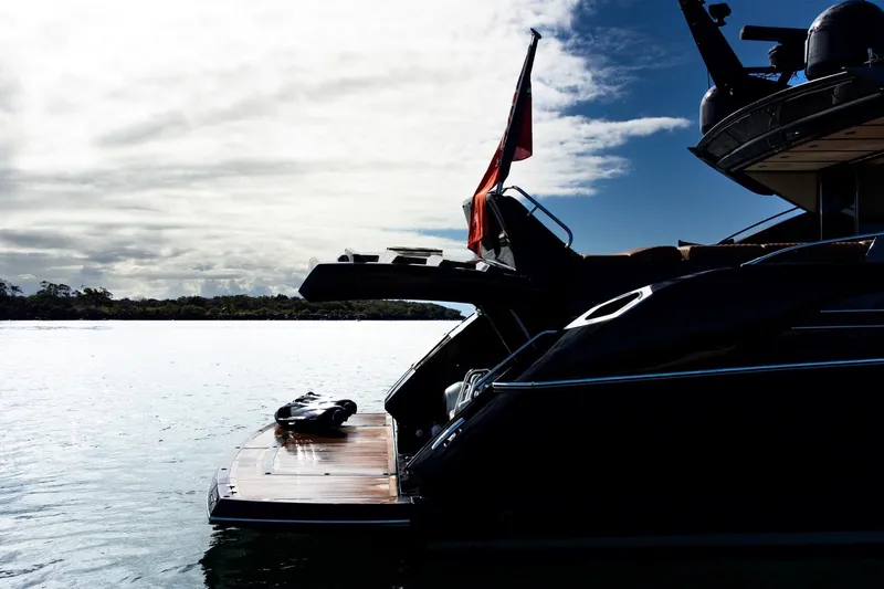 Zaza Yacht Photos Pics 2013 Sunseeker Predator 68 yacht docked, silhouetted against a cloudy sky.