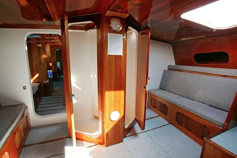 Christine Yacht Photos Pics Interior of a 1996 Custom 100' Sailing Yacht with wooden finishes and seating area.