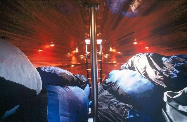 Christine Yacht Photos Pics Interior of a 1996 Custom 100' Sailing Yacht with wooden paneling and storage bags.