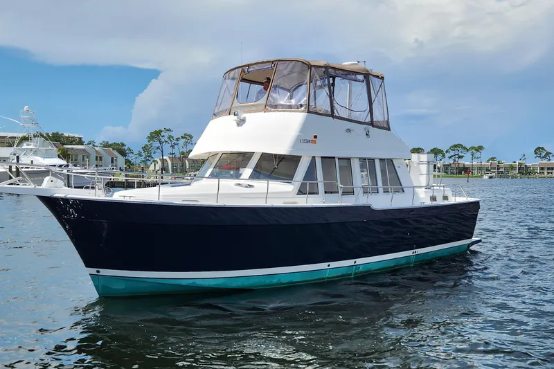  Yacht Photos Pics 2003 Mainship 43 Trawler Aft Cabin cruising on calm waters under a clear sky.