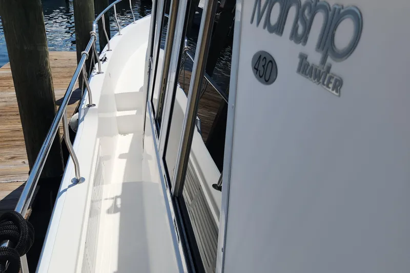  Yacht Photos Pics 2003 Mainship 43 Trawler Aft Cabin docked, showcasing sleek side deck and railing.