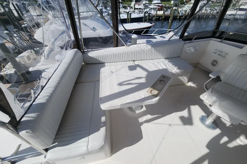  Yacht Photos Pics 2003 Mainship 43 Trawler Aft Cabin interior with white seating and table, docked at marina.