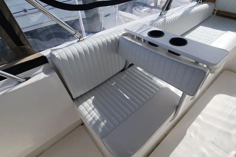  Yacht Photos Pics 2003 Mainship 43 Trawler Aft Cabin seating area with cup holders, featuring white upholstery.