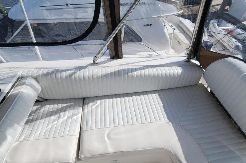  Yacht Photos Pics 2003 Mainship 43 Trawler Aft Cabin with white cushioned seating and clear enclosure.