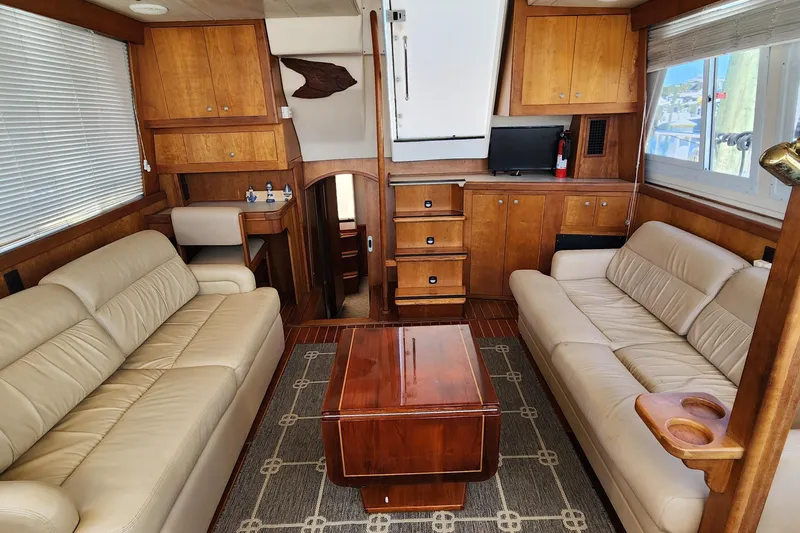  Yacht Photos Pics 2003 Mainship 43 Trawler Aft Cabin interior with leather sofas and wooden cabinetry.
