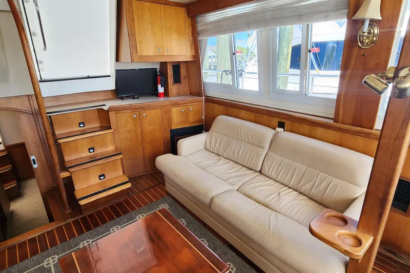  Yacht Photos Pics 2003 Mainship 43 Trawler Aft Cabin interior with sofa, stairs, and wooden cabinetry.