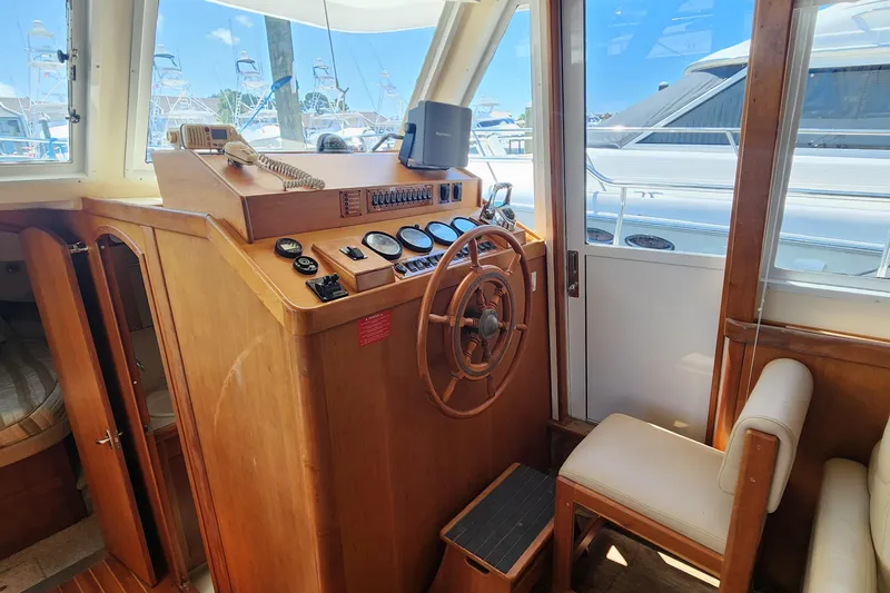  Yacht Photos Pics 2003 Mainship 43 Trawler Aft Cabin helm with wooden steering wheel and navigation instruments.