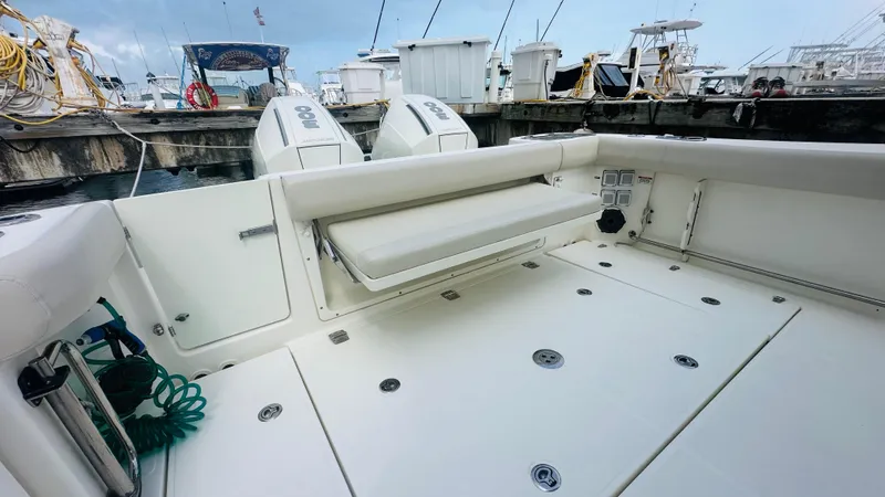  Yacht Photos Pics 2021 Boston Whaler 325 Conquest boat interior with seating and twin engines at dock.
