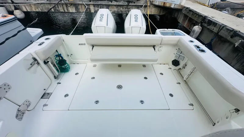  Yacht Photos Pics 2021 Boston Whaler 325 Conquest boat deck with seating and twin engines at dock.