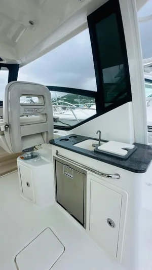  Yacht Photos Pics 2021 Boston Whaler 325 Conquest interior with sink and seating area.