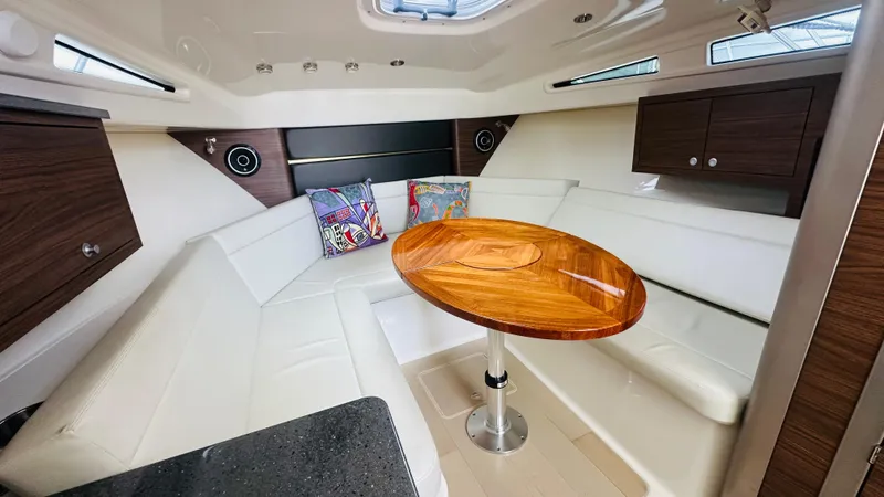  Yacht Photos Pics Luxurious interior of 2021 Boston Whaler 325 Conquest with wooden table and white seating.