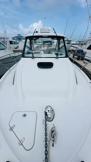  Yacht Photos Pics 2021 Boston Whaler 325 Conquest boat docked, showcasing sleek design and spacious deck.