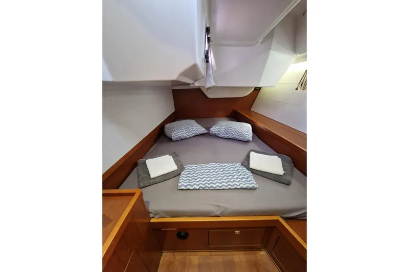  Yacht Photos Pics Cozy cabin interior of 2014 Beneteau Oceanis 48 with neatly arranged bedding.