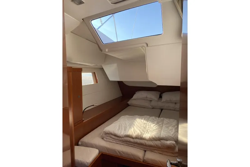  Yacht Photos Pics Cozy cabin interior of 2014 Beneteau Oceanis 48 sailboat with skylight and bedding.